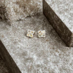 Clous d'oreilles dorés femme, carré ajouré pavé de strass et cristal central, posés sur pierre grise