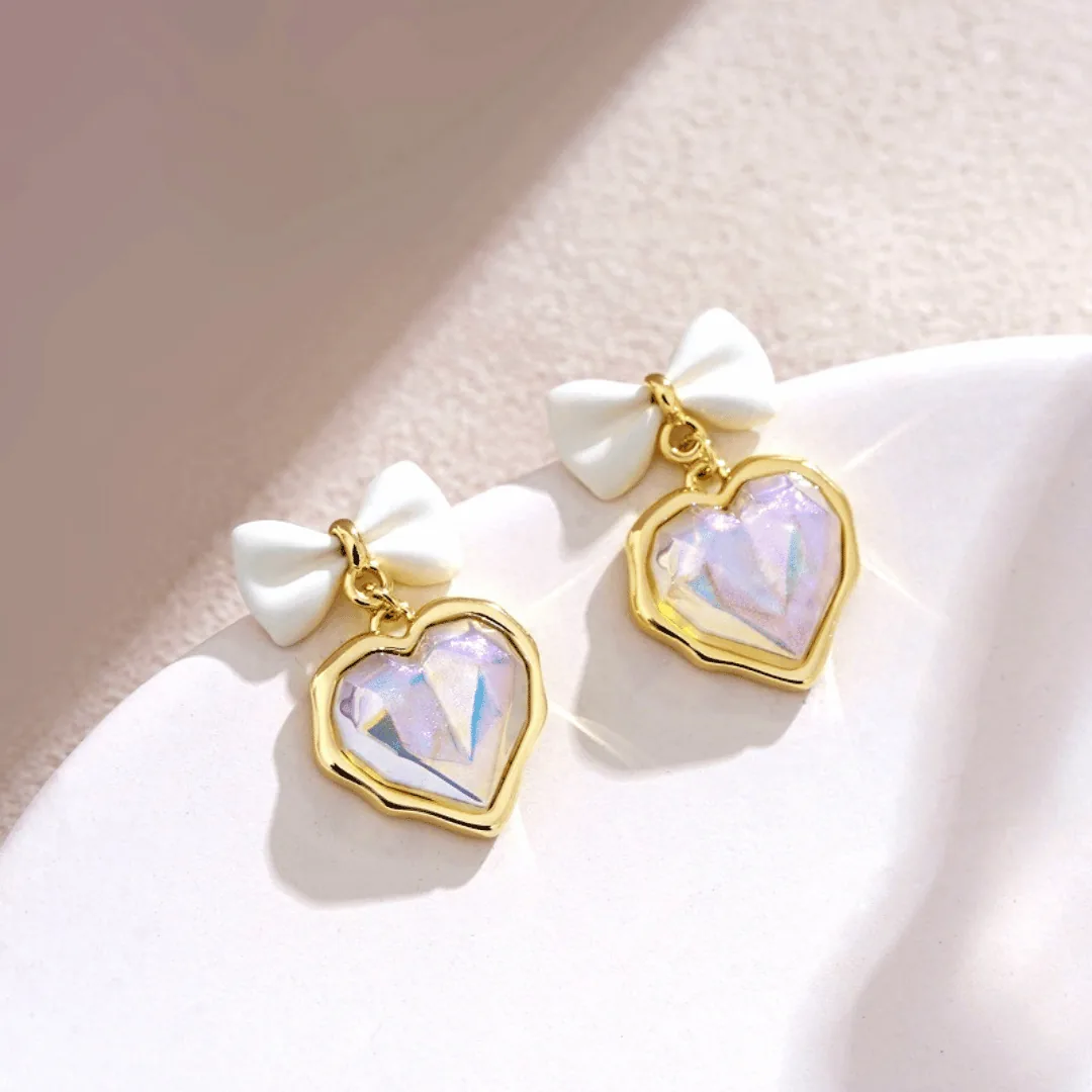 Boucles d'oreilles Nœud Blanc & Cœur Irisé – Pendentifs Scintillants Dorés en Acier Inoxydable – Image 1