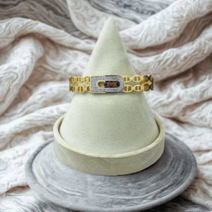 Bracelet jonc à maille ajourée dorée et boucle scintillante en cristaux sur présentoir cône
