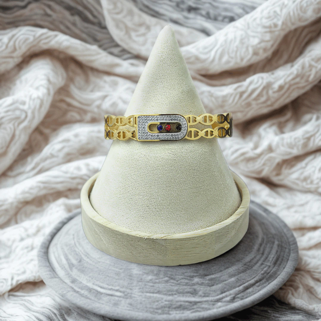 Bracelet jonc à maille ajourée dorée et boucle scintillante en cristaux sur présentoir cône