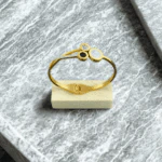 Bracelet jonc doré à médaillons chiffres romains sur un petit socle en bois, vue en plongée