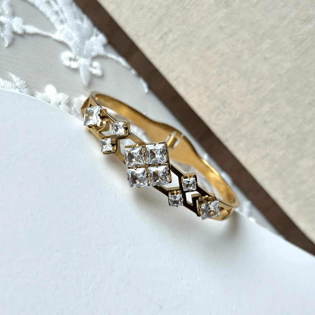 Détail des cristaux carrés sertis façon mosaïque sur le bracelet jonc doré ajouré