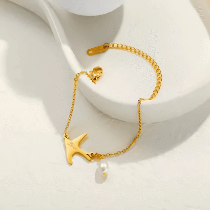 Bracelet chaîne fine dorée femme à pendentif hirondelle gravé Love et perle goutte, ajustable