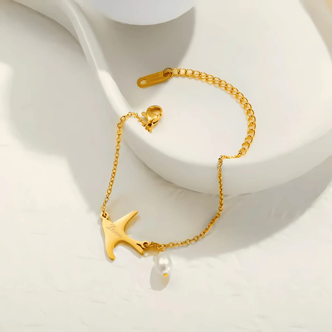 Bracelet chaîne fine dorée femme à pendentif hirondelle gravé Love et perle goutte, ajustable