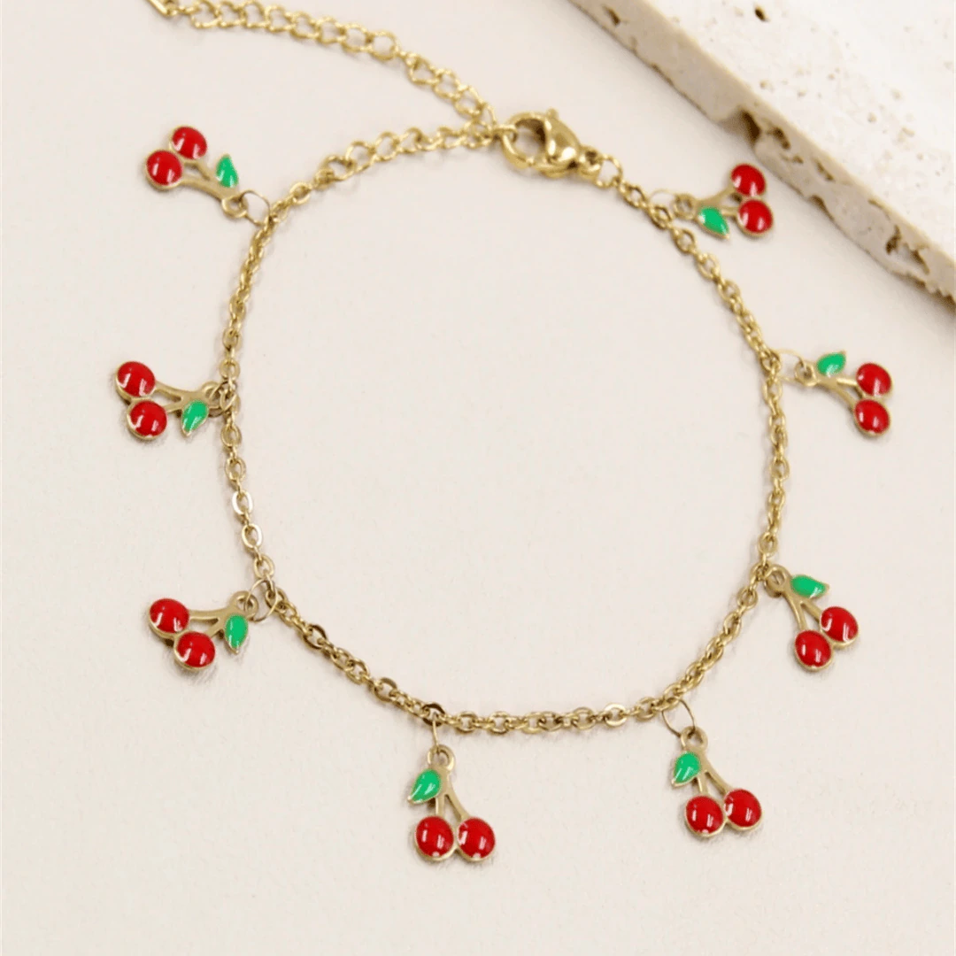 LV-BR-25 Bracelet chaîne fine doré femme à charms cerises rouges et feuilles vertes, posé à plat
