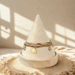 Bracelet double chaîne doré femme à disques dorés et charms mauvais œil bleus sur présentoir cône