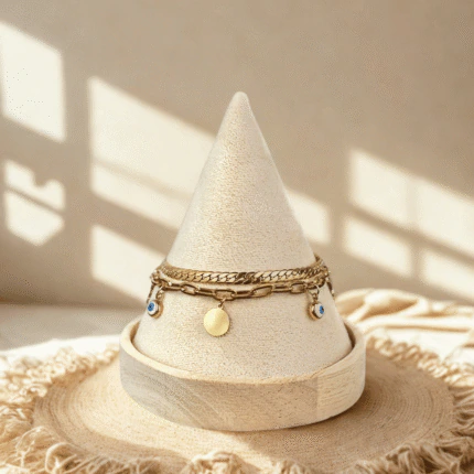 Bracelet double chaîne doré femme à disques dorés et charms mauvais œil bleus sur présentoir cône