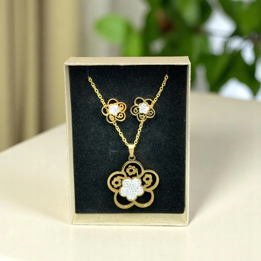 Parure fleur dorée dans son écrin noir : collier pendentif fleur en strass et puces d'oreilles