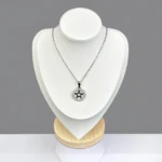 Collier pendentif étoile argenté dans un cercle serti de strass sur buste présentoir blanc