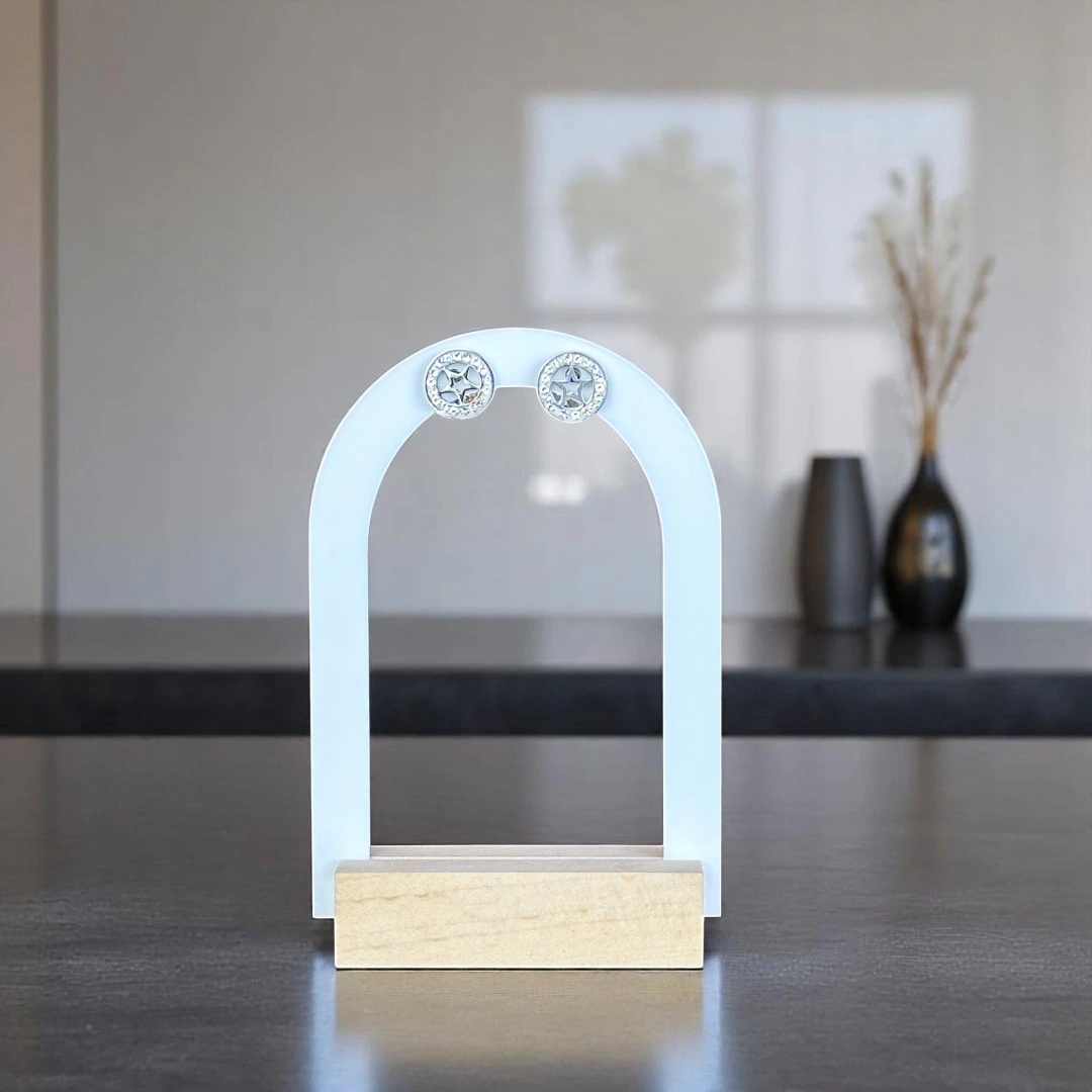 Puces d'oreilles étoile argentées à contour scintillant sur présentoir arche blanc