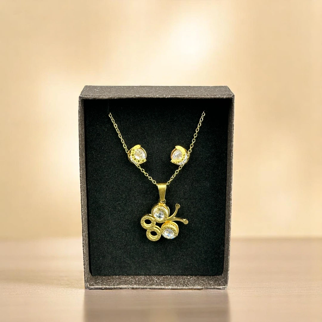 Parure papillon dorée dans son écrin noir : collier pendentif papillon et puces d'oreilles cristal