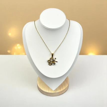 Collier papillon doré à pendentif serti de cristaux ronds sur chaîne fine, buste présentoir blanc