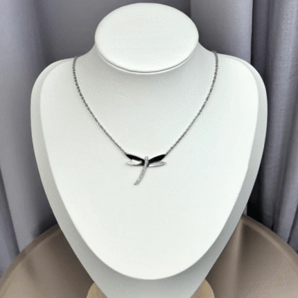 Collier libellule argentée à corps scintillant présenté sur un buste blanc