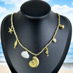 Collier coquillage doré femme à pendentif ammonite, étoile de mer, hippocampe et perle sur buste noir