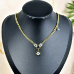 Collier mauvais œil doré femme, chaîne gourmette et pendentif octogonal serti de strass sur buste noir