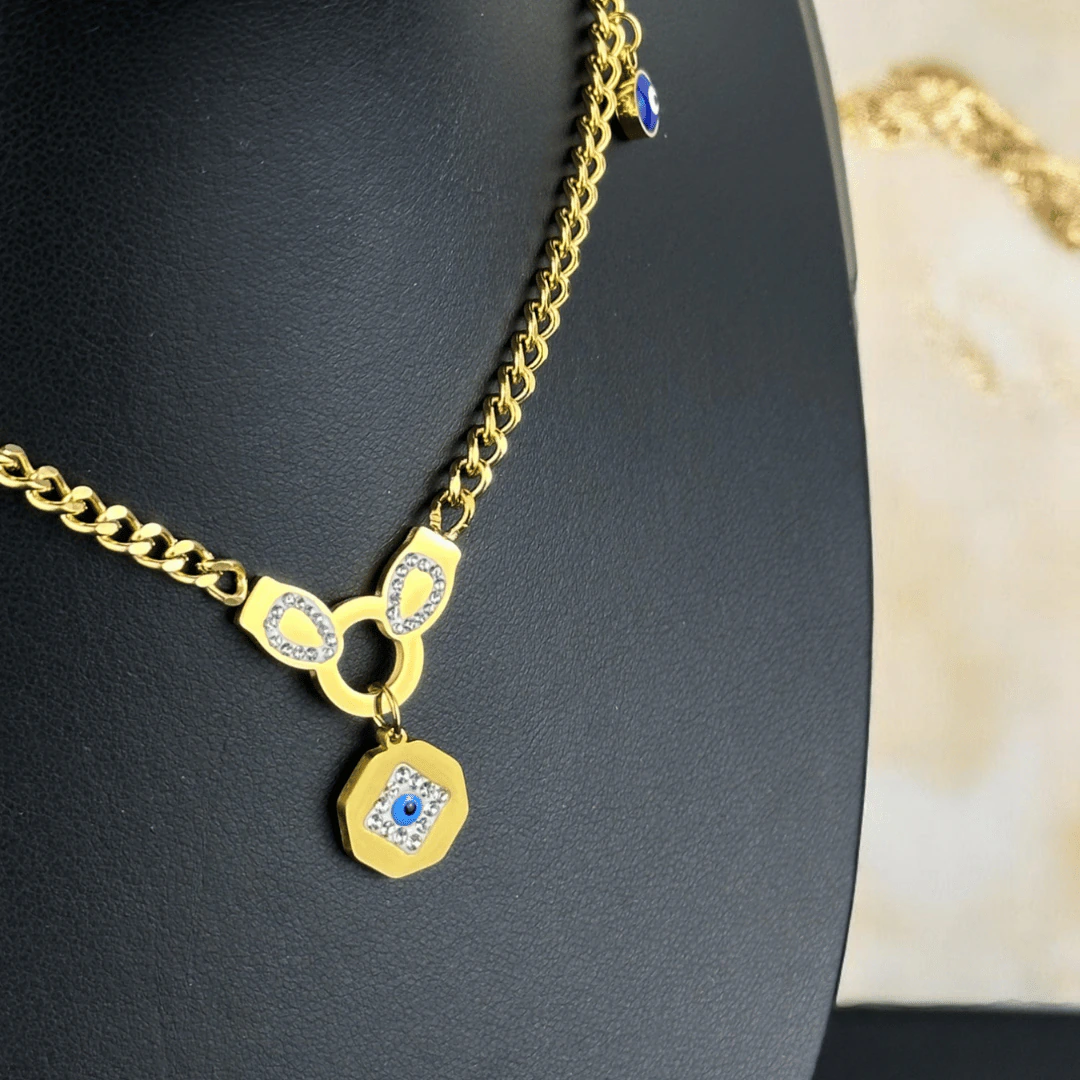 Vue de côté du collier œil protecteur doré : médaillon octogonal, attache strass et charm bleu