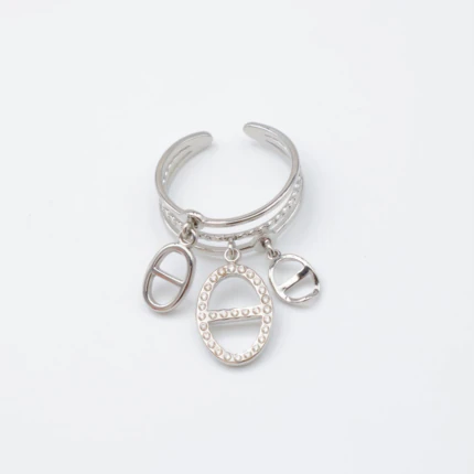 Bague ouverte argentée à anneaux multiples et trois charms ovales ajourés, fond blanc