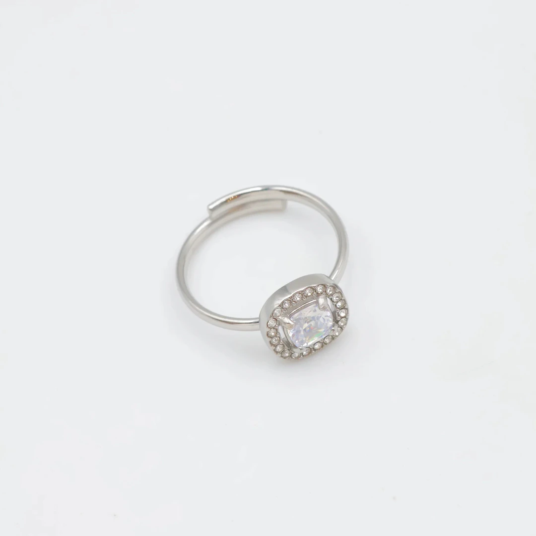 Bague femme argentée ajustable à pierre carrée brillante entourée de petits strass, sur fond blanc