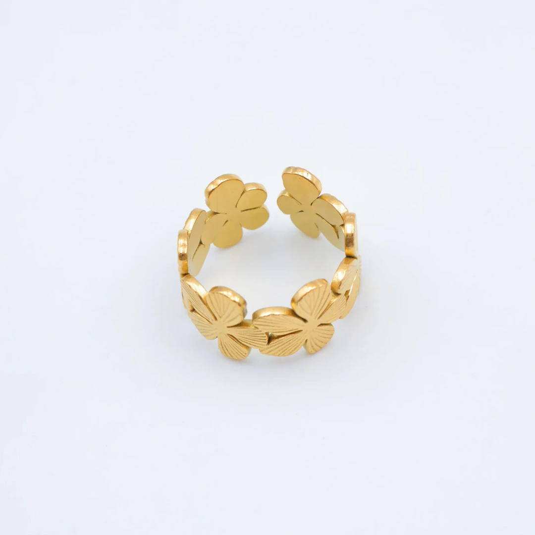 Bague femme dorée ouverte formée de fleurs délicates aux pétales striés, vue sur fond blanc