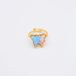 Bague ajustable dorée papillon bleu et fleurs roses en relief, anneau ouvert sur fond blanc