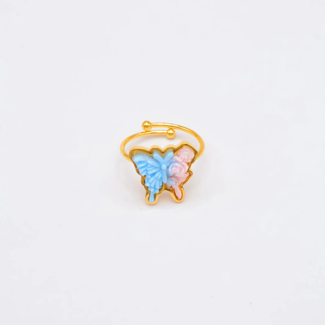 Bague ajustable dorée papillon bleu et fleurs roses en relief, anneau ouvert sur fond blanc