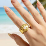 Bague femme dorée motif fleur détail blanc effet perlé