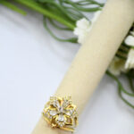 Bague femme dorée motif fleur pierres transparentes