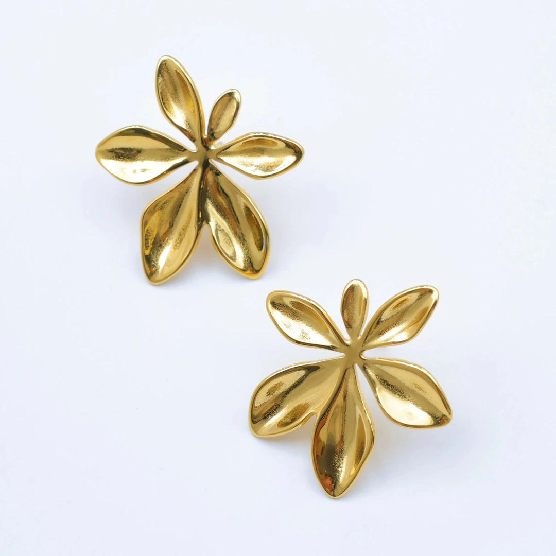 Paire de boucles d'oreilles fleur dorées à grands pétales bombés et brillants sur fond blanc
