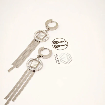 Paire de créoles argentées à cercle serti de strass, carré blanc et longues franges en chaîne sur fond blanc
