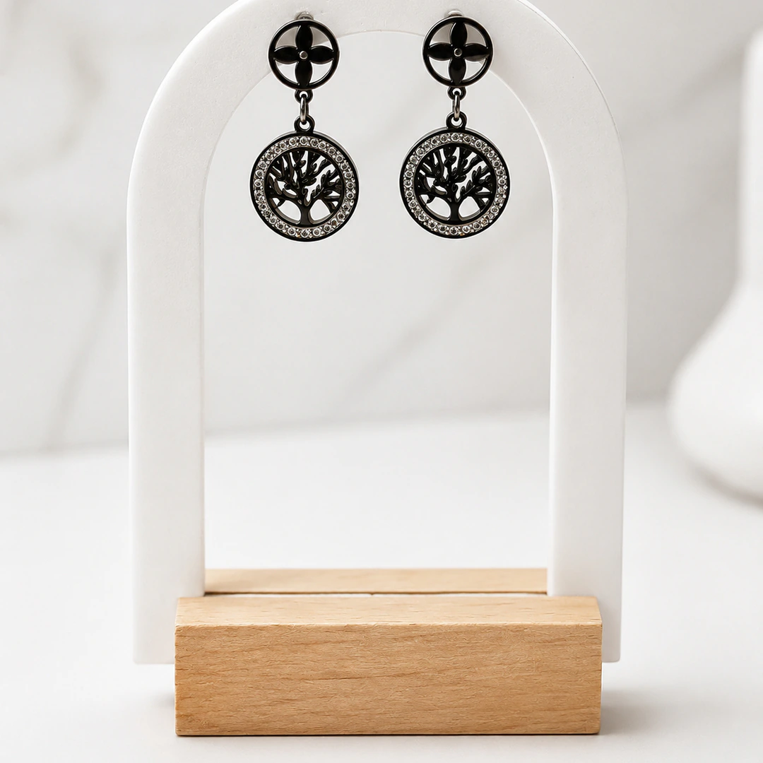 Boucles d'oreilles pendantes arbre de vie noir cerclé de strass et puce trèfle sur présentoir arche blanc