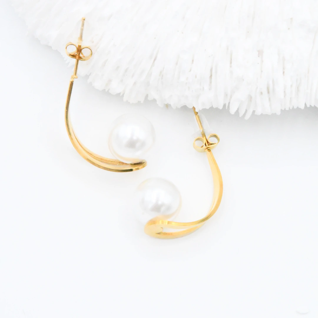Boucles d'oreilles demi-créoles dorées ouvertes à perle blanche posées à plat, poussoirs visibles