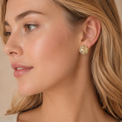Femme de profil portant une puce d'oreille dorée ronde et scintillante, vue rapprochée