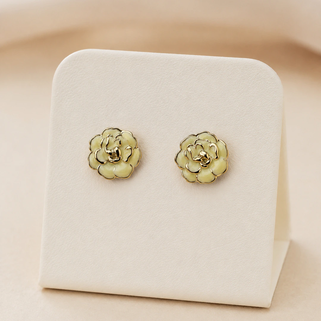Boucles d'oreilles clous fleur crème dorées femme, pétales bordés de doré, sur présentoir