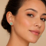 Femme portant des clous d'oreilles fleur turquoise au contour doré, vue de trois quarts