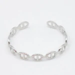 Bracelet jonc ouvert argenté à maillons ovales ajourés façon maille marine sur fond blanc