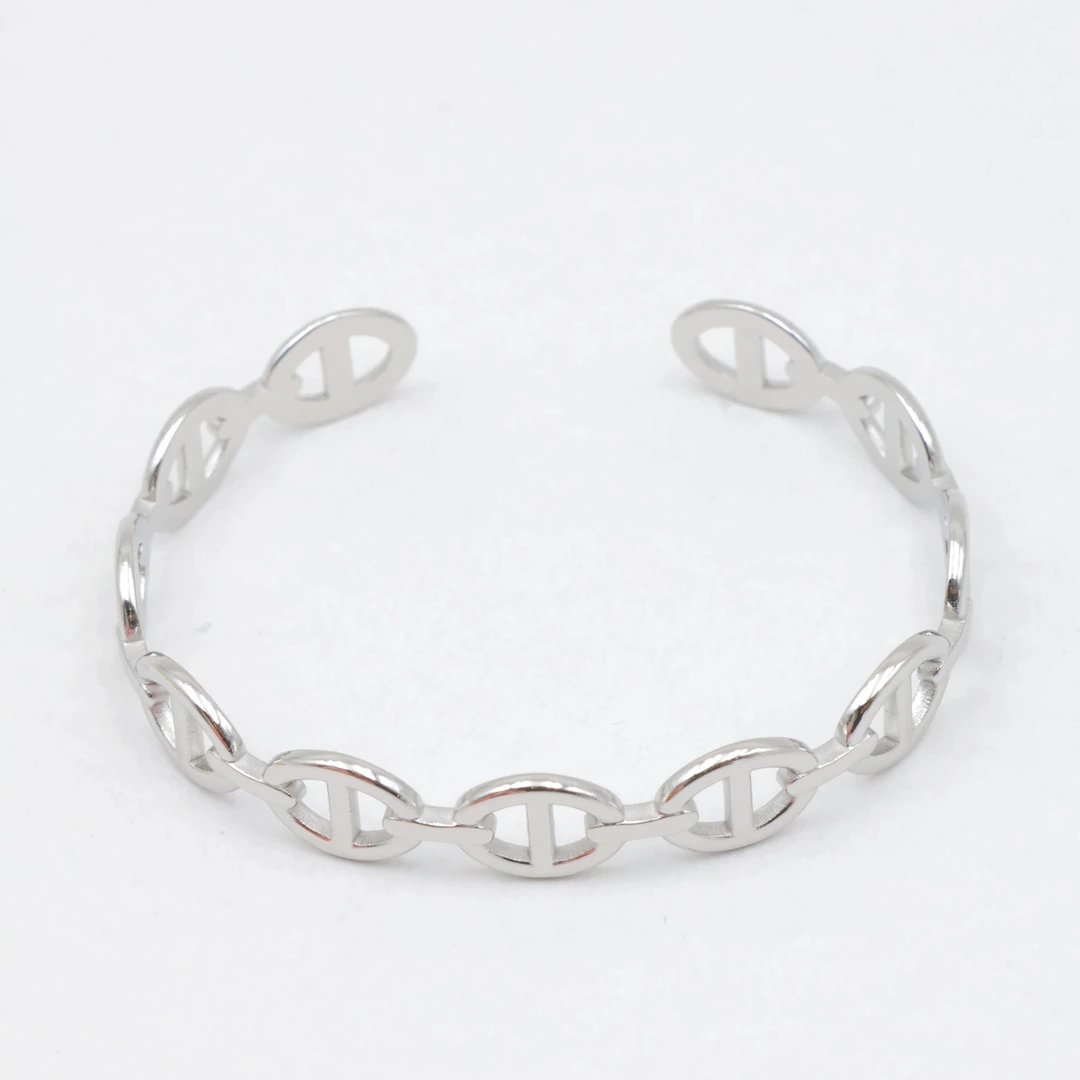 Bracelet jonc ouvert argenté à maillons ovales ajourés façon maille marine sur fond blanc