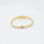 Bracelet jonc doré à charnière avec maillon ovale strassé, ligne de strass et maillons ajourés