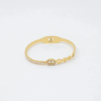 Bracelet jonc doré à charnière avec maillon ovale strassé, ligne de strass et maillons ajourés