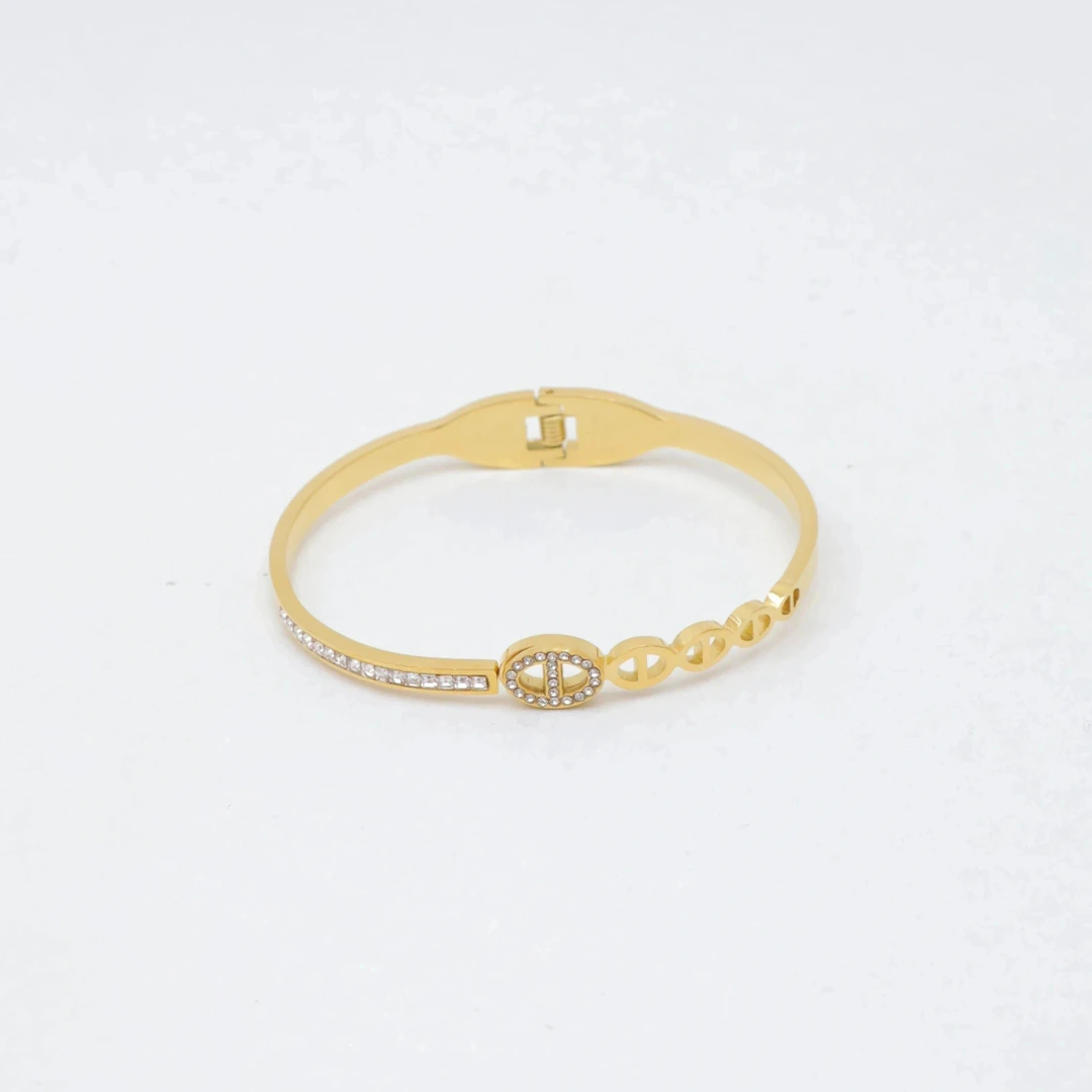Bracelet jonc doré à charnière avec maillon ovale strassé, ligne de strass et maillons ajourés