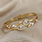 Bracelet jonc doré à feuilles blanches et cristaux en goutte avec son diamètre indiqué de 6,5 cm