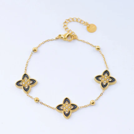 Bracelet doré femme à trois motifs trèfle noir sertis de strass sur chaîne fine perlée, avec rallonge