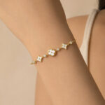 Bracelet doré femme fleurs blanches et détails brillants