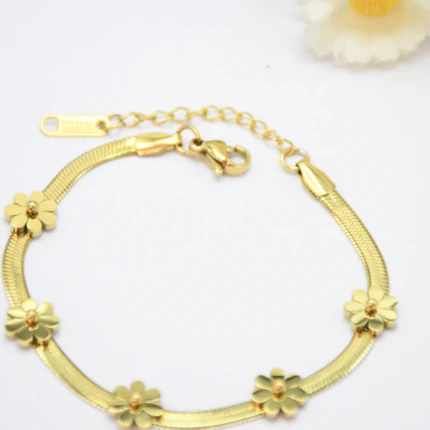 Bracelet maille souple plate dorée orné de petites fleurs dorées, fermoir mousqueton et rallonge