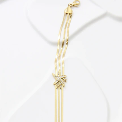 Bracelet trois rangs de chaînes plates dorées avec étoile de mer strassée et fermoir mousqueton