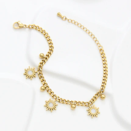 Bracelet gourmette doré déplié avec fermoir mousqueton, rallonge et trois charms soleil