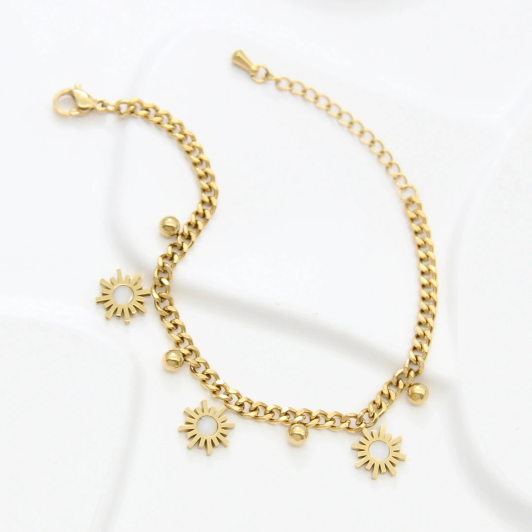 Bracelet gourmette doré déplié avec fermoir mousqueton, rallonge et trois charms soleil