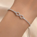 Bracelet argenté à motif infini brillant et fine ligne de strass porté au poignet