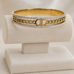 Bracelet jonc doré femme à maille chaîne centrale et deux lignes de strass sur présentoir crème