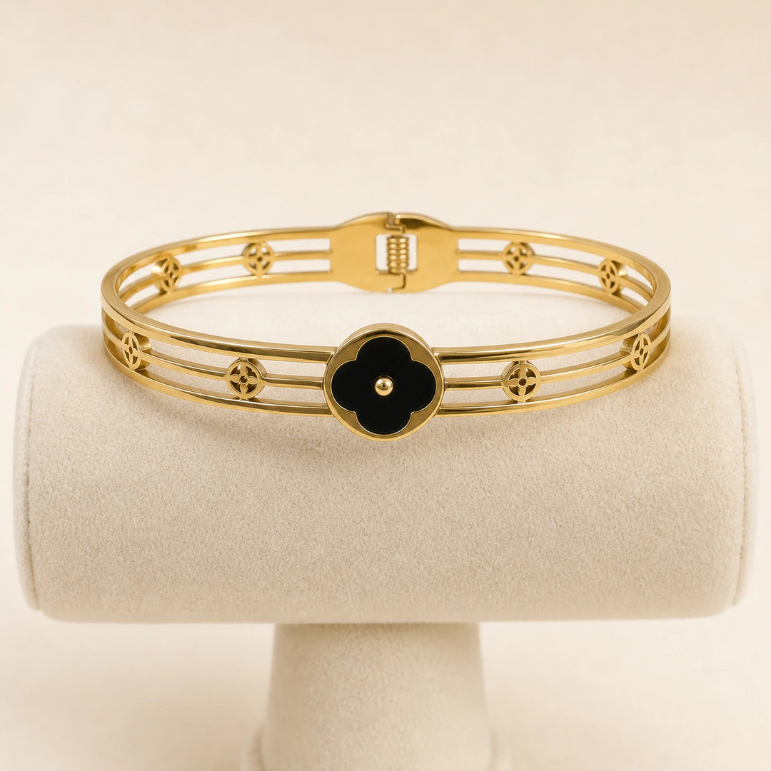 Bracelet jonc trèfle noir sur présentoir, vue des barres dorées et des petits trèfles ajourés