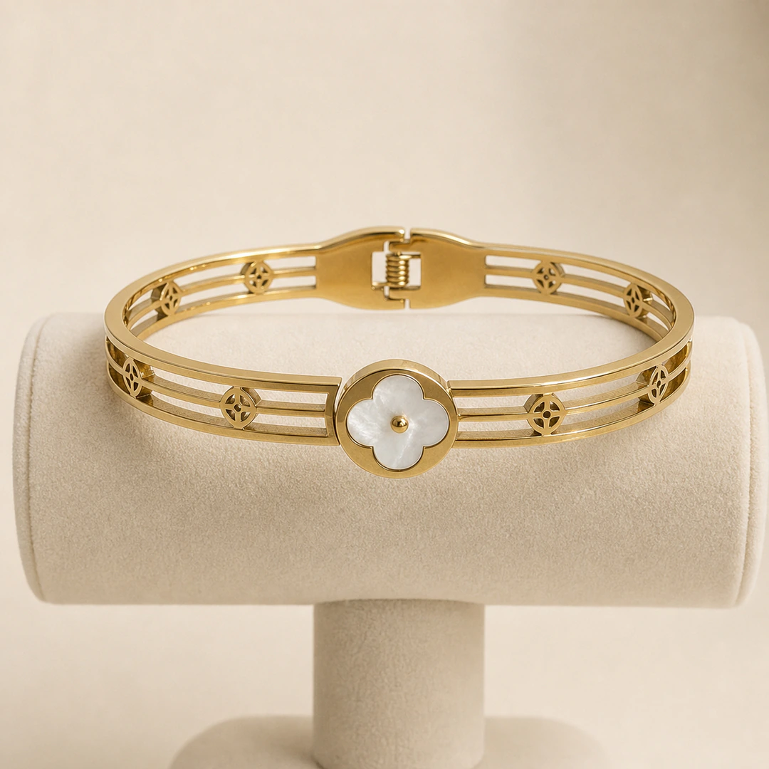 Bracelet jonc à trèfle blanc sur présentoir, vue du fermoir à charnière et des motifs ajourés